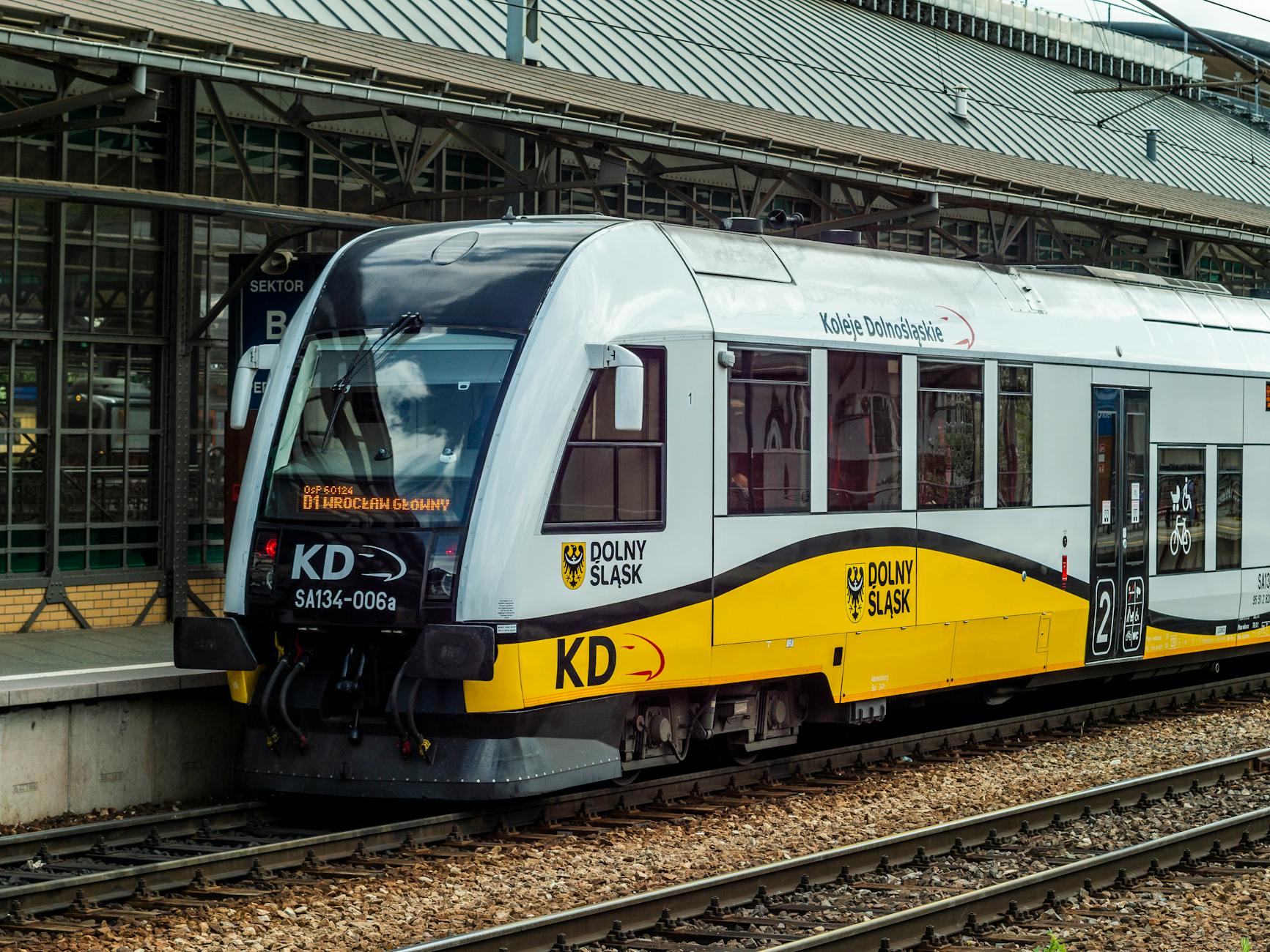 Ilustracja przedstawiająca pociąg na tle nowoczesnej infrastruktury kolejowej, nawiązująca do modernizacji linii do Berlina ze Szczecina.